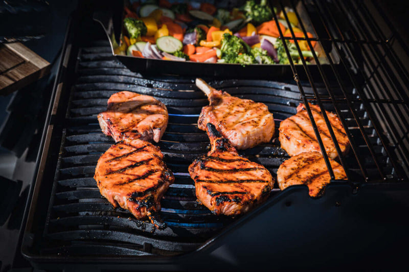 Direct vs Indirect heat methods for grilling; pork and vegetables shown on grill