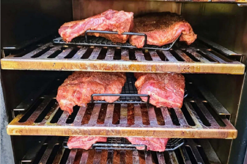 Myron Mixon Gravity-Fed Smoker with meat on the shelves. 