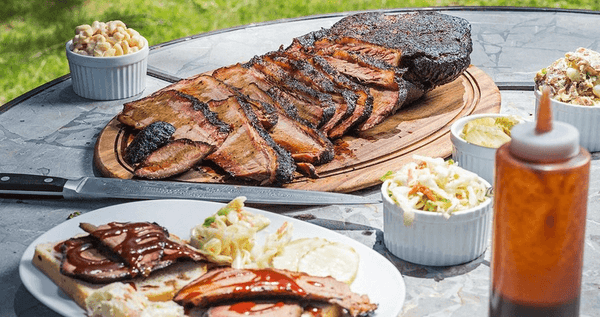 Picture of brisket on table with sides. 