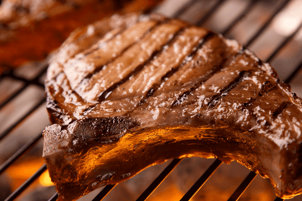 Bear & Burton’s W Sauce and Fireshire bottles with brisket, ribs, and burgers at DDR BBQ Supply