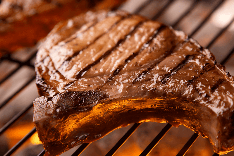 Bear & Burton’s W Sauce and Fireshire bottles with brisket, ribs, and burgers at DDR BBQ Supply