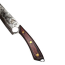 A close-up of the Spaceman Knives Meteor Series Chef Knife—a versatile 8.5-inch stainless steel knife with a hammered blade and wooden handle—rests on a marble-patterned surface beside a black cloth, ideal for any kitchen task.