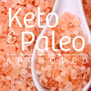 Close-up of The Spice Lab Himalayan Pink Salt Coarse Grain crystals with a white spoon. Text over the image reads Keto & Paleo Approved. Perfect for use in your salt grinder.