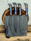The Texan Knives Handmade Damascus Steel Chef Knife Set, featuring five textured black knives with blue and brown handles in a speckled block, makes a perfect Valentine’s or wedding gift against a rustic wooden backdrop.