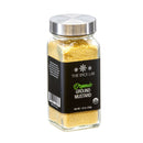 A clear glass jar with a silver lid holds The Spice Lab Organic Ground Mustard, a yellow organic ground mustard ideal for adding bold flavor to cheese dishes or elevating your favorite spice blends. The black label features The Spice Lab branding and the USDA Organic seal. Net weight: 1.6 oz (45 g).