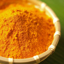 A close-up of The Spice Lab Turmeric Powder with Curcumin—vivid yellow-orange and packed with curcumin—in a woven basket, set against a hint of green background, showcasing this vibrant staple from The Spice Lab prized in kitchens worldwide.