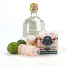An 8-pack of The Spice Lab Himalayan Salt Tequila Shooters, featuring two limes, a bottle of tequila, and a box labeled “Salt Shooters,” is artfully arranged on a white background—ideal for enhancing your next get-together with this distinctive party set from The Spice Lab.
