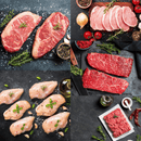 Collage featuring the Dude Food Gentleman’s Meat Box by Dude Food, displaying Kansas City Strip Steaks, pork chops, Boneless Chicken Breasts, and American Ground Beef arranged on dark surfaces with herbs, spices, onions, and olive oil.