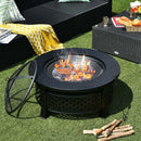 The DirectDeals Outdoor Fire Pit with BBQ Grill and High-temp Resistance Finish cooks food over flames, surrounded by wicker patio furniture, a yellow patterned blanket, a bread and drinks tray, and firewood on the grass.
