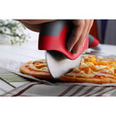 A hand uses the WPPO Pizza Cutter With Removable Safety Shield by WPPO LLC Direct, featuring a large red handle and a sharp stainless steel blade, to slice a cheese and vegetable pizza on a white table with a striped cloth.