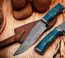 The Texan Knives Custom Handmade 13" Damascus Steel Confederate Civil War Bowie Knife with a camel bone handle rests on its leather sheath, displayed on a wooden surface with textured brown objects nearby.
