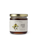 A glass jar of Georgetown Olive Oil Co Raw Unfiltered Varietal Honey with a gold lid. The label displays a botanical illustration of an avocado blossom and a bee, and lists the product weight as 9.5 oz (269g). This California varietal honey is raw and unfiltered, capturing the pure essence of its unique source.