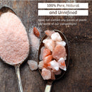 Two spoons rest on a wooden surface: one contains The Spice Lab Himalayan Pink Salt Coarse Grain crystals, ideal for your salt grinder, while the other holds fine pink salt powder. The text above emphasizes that this salt by The Spice Lab is 100% pure, natural, unrefined, and free of plastic.