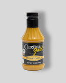 A plastic bottle of Gourmet Carolina Gold BBQ Sauces with a black label reading Carolina Gold Honey Sauce.