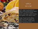 A slice of apple strudel with apple pieces, dusted with powdered sugar and a touch of Spice Wheel Apple Sugar by Spice Wheel, sits next to orange slices and walnuts, alongside text about Spice Wheel Apple Sugar and its origin.