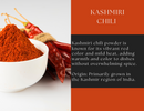 A white bowl filled with vibrant red Spice Wheel Kashmiri Chili powder, renowned for its mild heat and brilliant color, sits beside dried red chilies on a white surface, with descriptive text about Spice Wheel Kashmiri Chili displayed to the right.