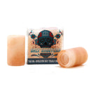 Two shot glasses from The Spice Lab Himalayan Salt Tequila Shooters 2 Pack are positioned in front of a box featuring the brand’s signature skull design. Crafted by The Spice Lab, one glass stands upright while the other rests on its side, showcasing their unique construction from Himalayan salt.