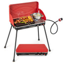 The DirectDeals 2-in-1 Gas Camping Grill and Stove with food skewers, vegetables, and a pot cooks on dual burners atop four legs, featuring a propane hose and a red lid set nearby.