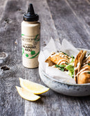 Terrapin Ridge Farms Jalapeno Aioli Squeeze Garnishing Sauce sits beside tacos topped with sauce and greens plus lemon wedges—a creamy, zesty condiment by Terrapin Ridge Farms ideal for dipping or garnishing.