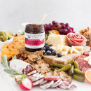 Terrapin Ridge Farms Hot Pepper Bacon Jam, paired with assorted meats, cheeses, crackers, pickles, and fruit on a white charcuterie board—ideal for stylish entertaining.