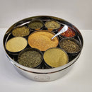 The Spice Wheel Italian Spice Wheel by Spice Wheel is a circular stainless steel spice organizer elegantly designed with eight separate compartments, each filled with a different spice—including red pepper flakes, rosemary, classic Italian herbs and spices, as well as an array of dried herbs and ground powders. A small silver spoon sits at the center for easy serving. This makes a thoughtful kitchen gift for any culinary enthusiast.