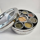 The Spice Wheel Italian Spice Wheel by Spice Wheel is a round stainless steel spice organizer featuring a transparent lid, eight spice-filled containers, and a small metal spoon—all arranged in an elegant display on a white surface. Perfect as a thoughtful kitchen gift, it’s the stylish solution for storing your favorite Italian herbs and spices.