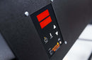 Close-up of a digital control panel featuring red LED displays, a power button, and arrow buttons, labeled Smokin Brothers. The panel is mounted on a textured black surface—likely part of a smoker or grill—and is part of the Smokin Brothers Que-View Controller Upgrade Kit. This advanced controller allows for precise temperature control and offers remote cook monitoring via WiFi grill connectivity.