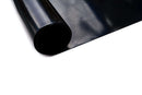 A close-up of a partially unrolled Smokin Brothers Drip Pan Liner Small (15.25″ x 20″) by Smokin Brothers on a white surface, ideal as a reusable liner to simplify grill cleanup.