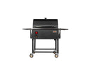 The Smokin Brothers Stainless Steel Side Shelf, designed for Premier and Premier Plus Models, is shown attached to a black, rectangular outdoor grill. The setup features a closed lid, control panel, and four caster wheels to enhance mobility and workspace. This accessory from Smokin Brothers is displayed against a plain white background.
