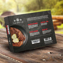 A box of The Spice Lab Taste of America Seasoning Collection by The Spice Lab rests on a wooden table; the packaging displays an image of fried chicken with pickles, includes detailed flavor descriptions and a barcode on a sleek black background, showcasing American-inspired seasoning blends ideal for grilling spice enthusiasts.