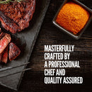Sliced grilled steak on a stone tray, garnished with a sprig of rosemary, is served alongside a square bowl filled with flavorful red spice from The Spice Lab Grilling Seasoning Collection. Text reads: Masterfully crafted by a professional chef and quality assured by The Spice Lab.