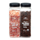 A combo pack from The Spice Lab featuring two clear jars with black lids—one contains coarse Himalayan pink salt and the other organic black Tellicherry peppercorns. Both jars are labeled with The Spice Lab brand name and product names in white text.