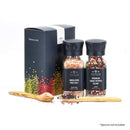 The Spice Lab Himalayan Pink Salt & Premium Kings Pepper Grinder Set by The Spice Lab features two glass jars with black lids, presented in a sleek black gift box, alongside two wooden spoons and spices displayed on a white background. *Spoons not included. Perfect as an elegant addition to your kitchen or as a thoughtful gift.