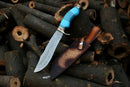 The Texan Knives Hand Made Damascus Steel Hunting and Camping Knife features a blue handle, ornate detailing, and comes with an original leather cover—an ideal gift for him or Christmas.