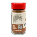 A glass spice jar with a red lid displays the Powerful Pepper Company’s "Powerful Pepper Steak Seasoning No. 5" label, detailing its gourmet blend of steak seasoning ingredients and flavors—including the bold richness of black garlic. The label also features a QR code and website link for more recipes and information.