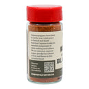 A clear jar with a red lid contains Powerful Pepper Cajun Blackening Seasoning by Powerful Pepper Company. The label describes the seasoning’s history, highlights its use in Cajun blackened recipes, and notes that it is extra hot. There is also a QR code and website link on the label.