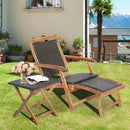 The DirectDeals 3 Pieces Patio Rattan Folding Lounge Chair Set of 2 with Acacia Wood Table sits on green grass with pink roses and an open book—ideal for outdoor relaxation near buildings, a palm tree, and scenic mountains.