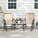The DirectDeals 2-Seater Outdoor Glider Bench with Center Table features beige chairs with metal frames, set on a stone patio in front of a white siding wall, perfect for relaxing with mugs and books.