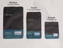 Three black and teal spice bags labeled Medium (1 cup), Small (1/2 cup), and Sample (2 tablespoons) are displayed side by side on a white marble surface, perfect for storing aromatic World Spice Basil by World Spice to enhance Mediterranean dishes with its fresh, vibrant flavor.