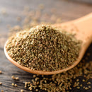 A wooden spoon filled with The Spice Lab Whole Celery Seeds, a savory seasoning from The Spice Lab, sits on a wooden surface, with some seeds scattered around.