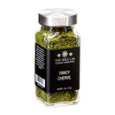 A clear glass jar with a silver lid holds dried chervil, a classic herb in French cuisine and part of the traditional fines herbes. The black label displays The Spice Lab brand and product name, Fancy Chervil, with a net weight of 4 oz. (113g).