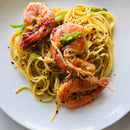 Spaghetti topped with whole shrimp and sliced green peppers is finished with a sprinkle of The Spice Lab Organic Crushed Red Pepper Flakes, bringing classic Italian cooking flavors to your table.
