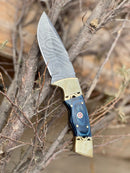 The Texan Knives Hunting Knife features a 9" forged Damascus steel blade, Pakka wood handle, brass bolster, and comes with a leather sheath—making it an eye-catching upgrade to your premium outdoor gear collection.