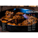 A close-up of a cast-iron skillet brimming with Spanish rabbit stew, generously coated in a rich, dark chocolate sauce. The cookbook-style page displays the title "WPPO Badass Backyard Cooking Cookbook - 140 of my Favorite Outdoor Cooking Recipes" by WPPO LLC Direct, with a neatly organized list of ingredients on the left and step-by-step cooking instructions on the right—ideal for BBQ enthusiasts and anyone seeking unique inspiration from an outdoor cooking cookbook.