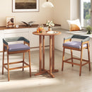 A cozy room features two wooden chairs, a tall round table with drinks and books, and a DirectDeals 880 lbs Utility Wagon Flatbed with Removable Oxford Cloth Liner tucked by the window seat, adding charm to the relaxed atmosphere.