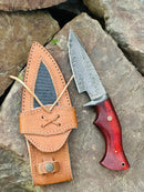 The Texan Knives Hunting Skinning Knife features a 10" Damascus steel blade, a polished pakkawood handle, and comes with a tan leather sheath—ideal for outdoor enthusiasts.