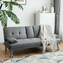 A modern gray sofa with metal legs sits on a geometric rug. The DirectDeals Patio Acacia Wood Dining Set for Home adds space-saving style and complements the bright room’s decor and potted plant.