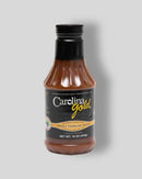 A 16-ounce bottle of Gourmet Carolina Gold Mix-and-Match 6-Pack of Gourmet Carolina Gold BBQ Sauces with a black label, perfect for those who enjoy authentic South Carolina BBQ.