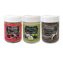 Three glass jars of the Saltopia Flavor Trio Set – Hot Honey, Lime Garlic & Za’atar Infused Sea Salts, featuring labels for Hot Honey, Lime Garlic, and Zaatar Spice Blend.