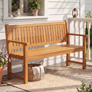 The DirectDeals 3-Seater Wooden Garden Bench with Backrest, 59 Inch sits on a porch by a white wall, window, lantern, bird figurine, blanket basket, and woven rug. Sunlight highlights the outdoor seating.